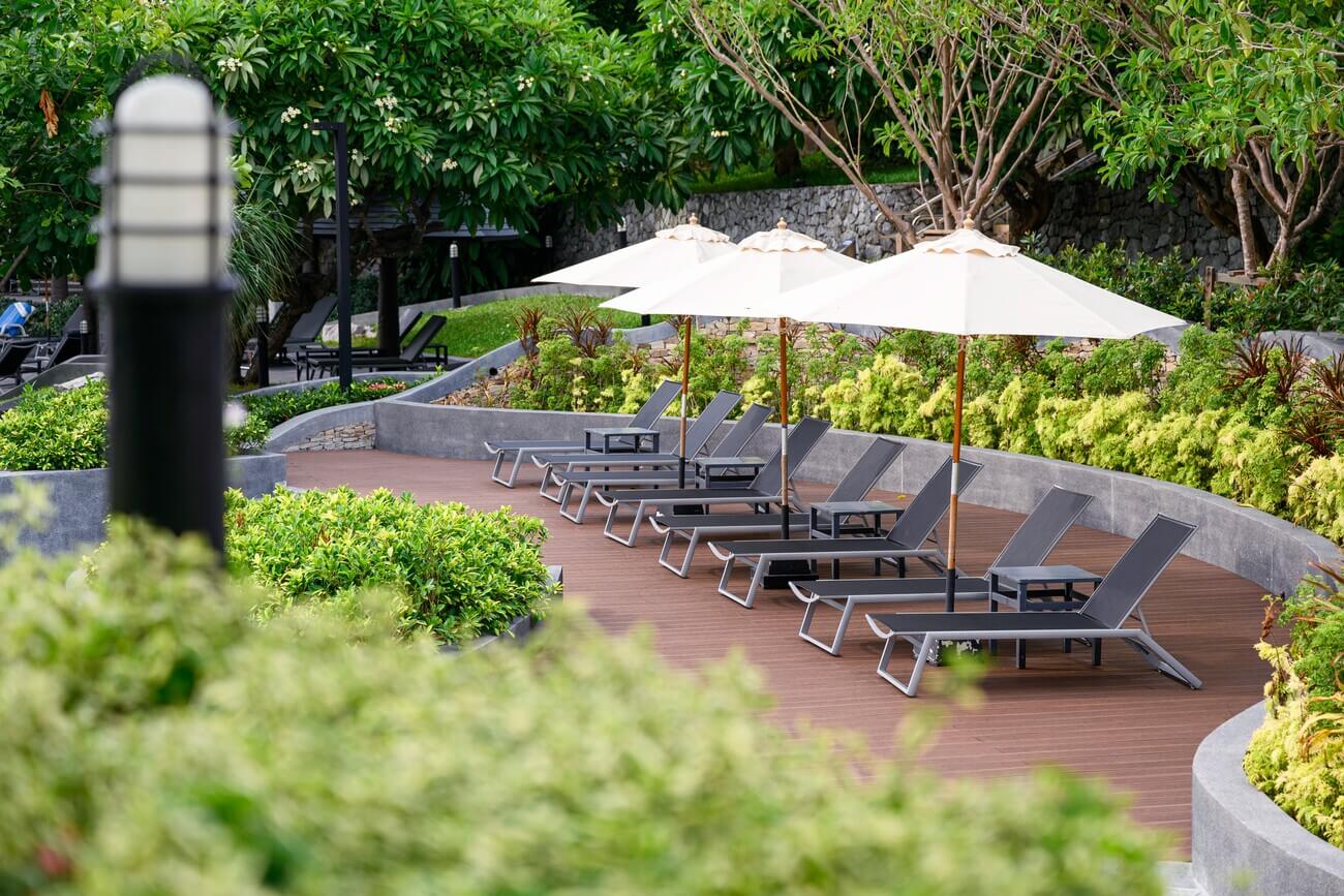 sunbeds-with-parasol-on-wooden-patio-at-poolside-i-2023-11-27-04-57-34-utc.jpg